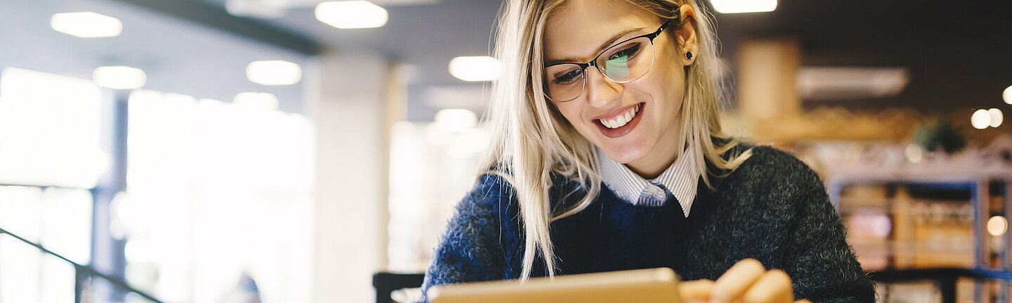Studierende mit Tablet in der Bibliothek Studierende mit Tablet in der Bibliothek