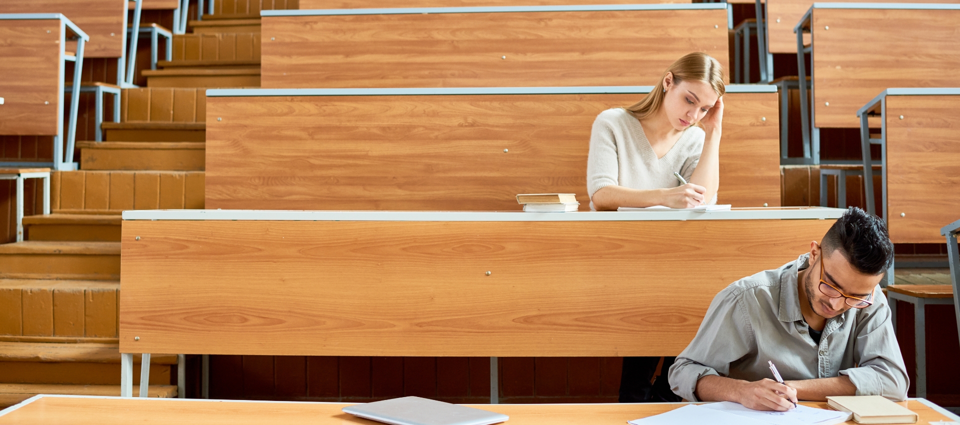 Zwei Studierende im Hörsaal sitzend